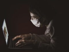 girl with a mask using computer