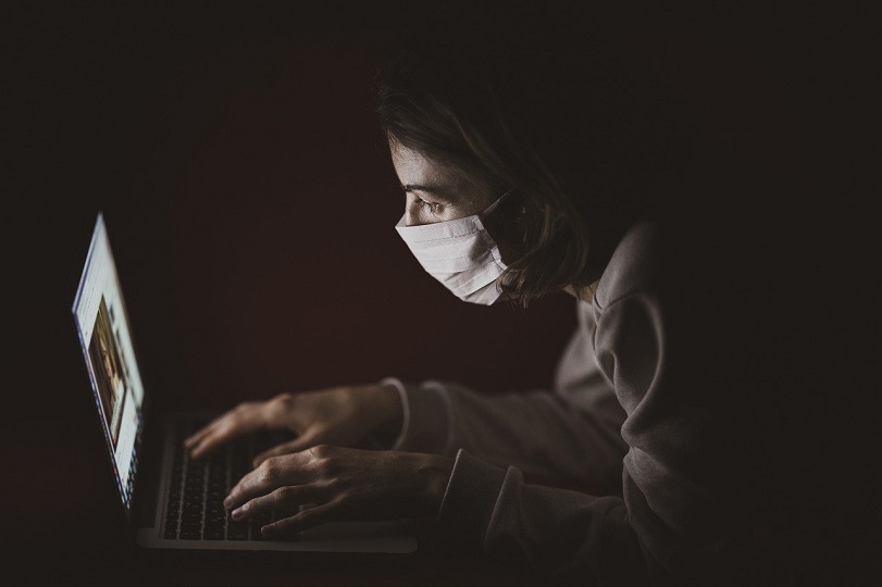 girl with a mask using computer